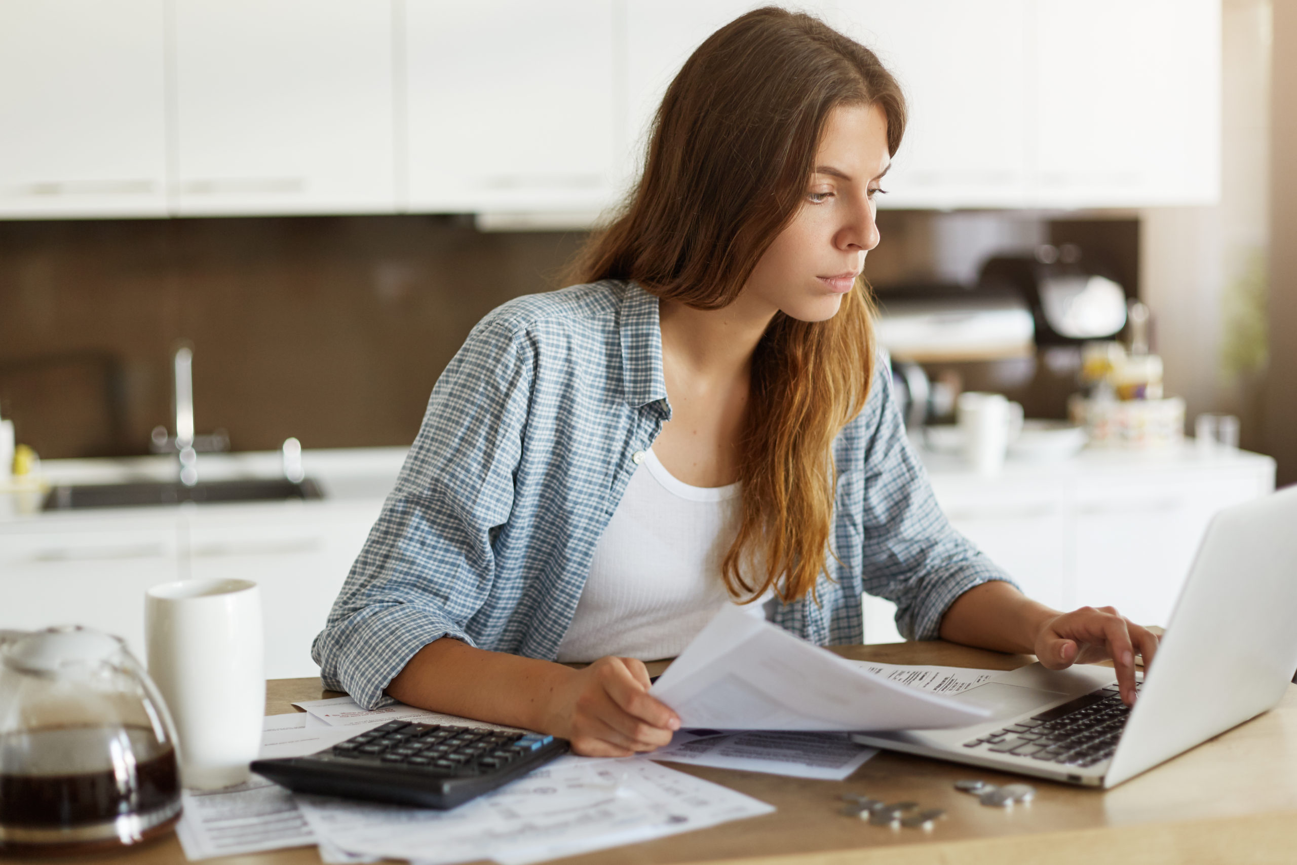 young woman checking her budget doing taxes scaled 1